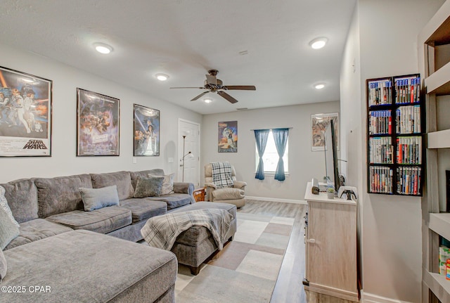 living room with ceiling fan and light hardwood / wood-style flooring