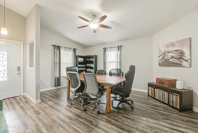 dining room with ceiling fan, vaulted ceiling, and wood-type flooring