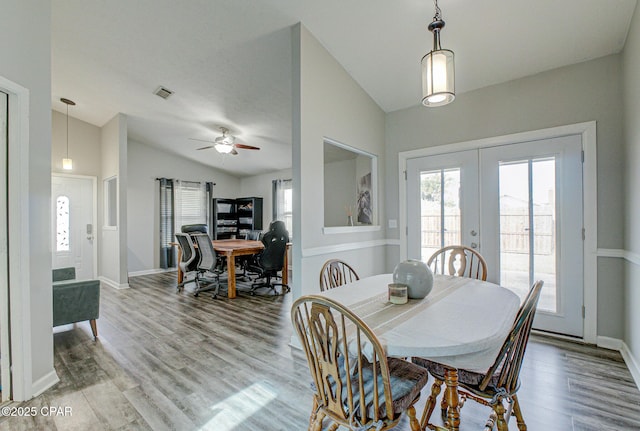 dining area with hardwood / wood-style flooring, vaulted ceiling, and french doors