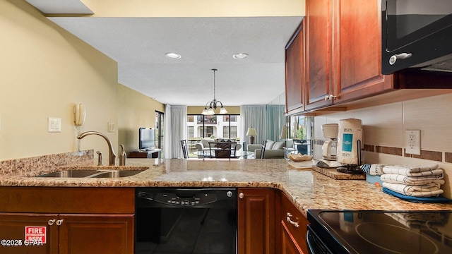 kitchen with light stone countertops, a peninsula, a sink, and black appliances