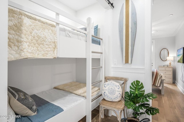 bedroom with crown molding and wood-type flooring