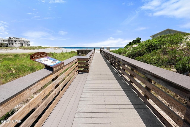 surrounding community featuring a water view and a beach view