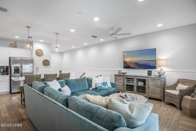 living room with ceiling fan and light hardwood / wood-style flooring