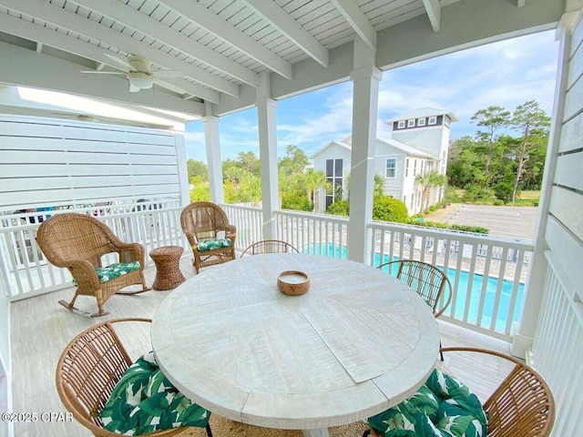 sunroom / solarium with ceiling fan, wood ceiling, and beam ceiling