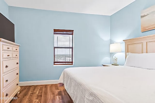 bedroom with baseboards and wood finished floors