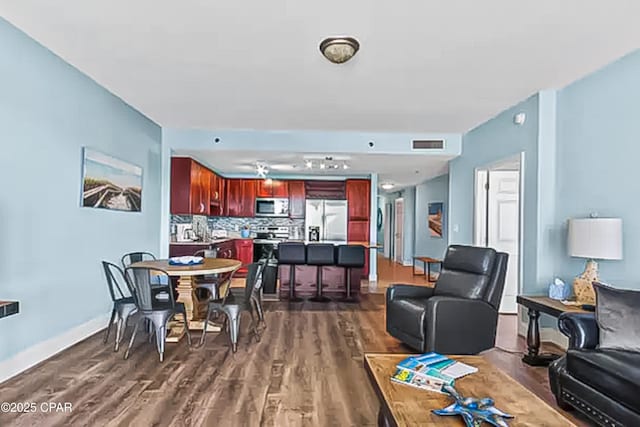 dining space featuring visible vents, baseboards, and dark wood-style flooring