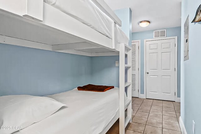 bedroom featuring light tile patterned flooring, baseboards, and visible vents