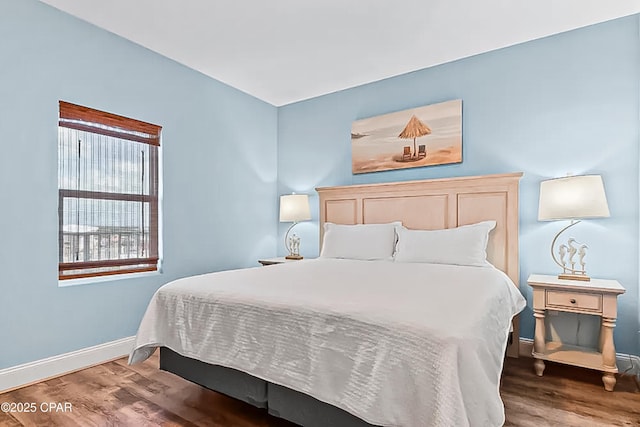 bedroom with baseboards and wood finished floors