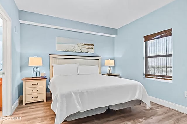 bedroom featuring baseboards and light wood finished floors