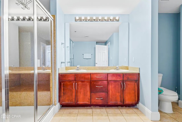 full bathroom featuring double vanity, a shower stall, toilet, and a sink