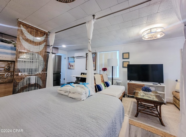 bedroom featuring a wall mounted air conditioner and wood finished floors