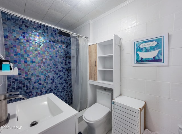 bathroom featuring toilet, a tile shower, and tile walls