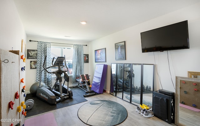 exercise room with light wood-type flooring