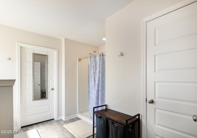 bathroom with wood-type flooring and a shower with shower curtain