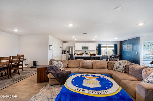 living room featuring a textured ceiling and light wood-type flooring