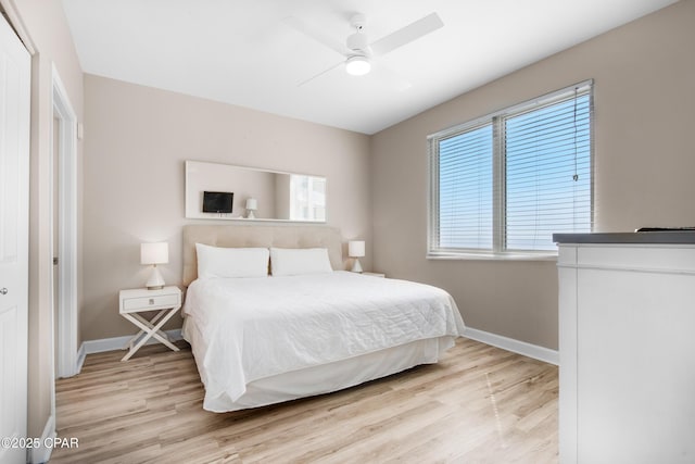 bedroom with a ceiling fan, light wood-style flooring, and baseboards