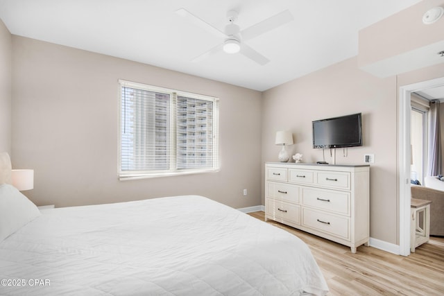 bedroom featuring a ceiling fan, baseboards, and light wood finished floors