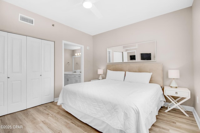 bedroom featuring light wood-style flooring, connected bathroom, visible vents, and a closet