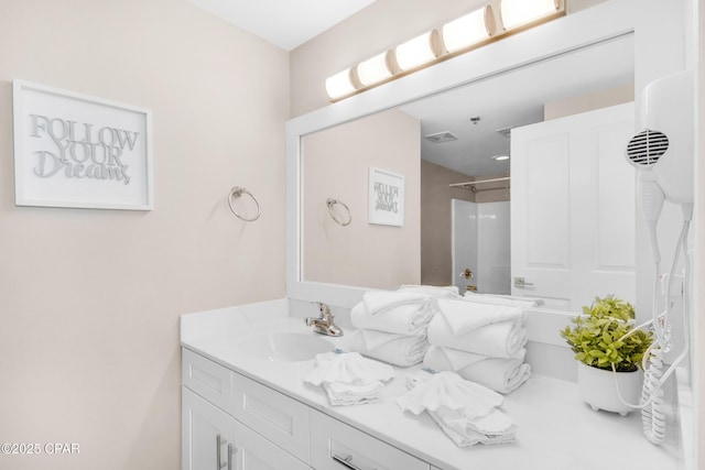 bathroom featuring a shower and vanity