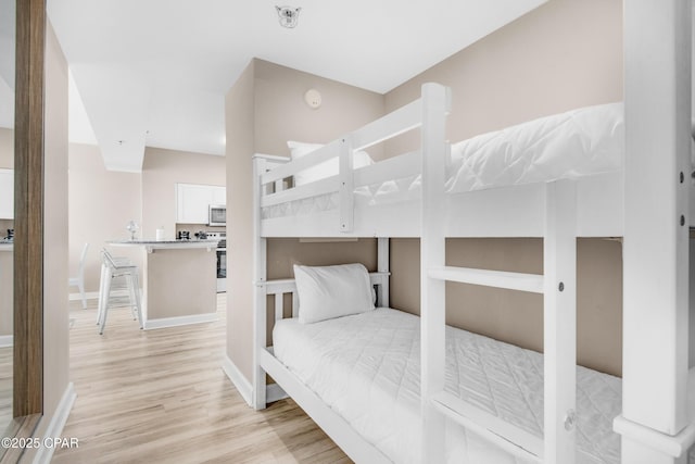 bedroom featuring baseboards and light wood-style floors