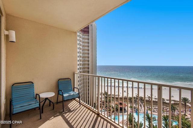 balcony featuring a water view and a beach view