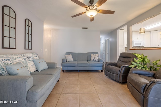 tiled living room featuring ceiling fan