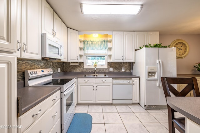 kitchen with sink, backsplash, white cabinets, light tile patterned floors, and white appliances