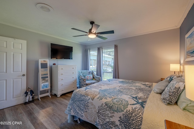 bedroom featuring hardwood / wood-style floors, ornamental molding, and ceiling fan