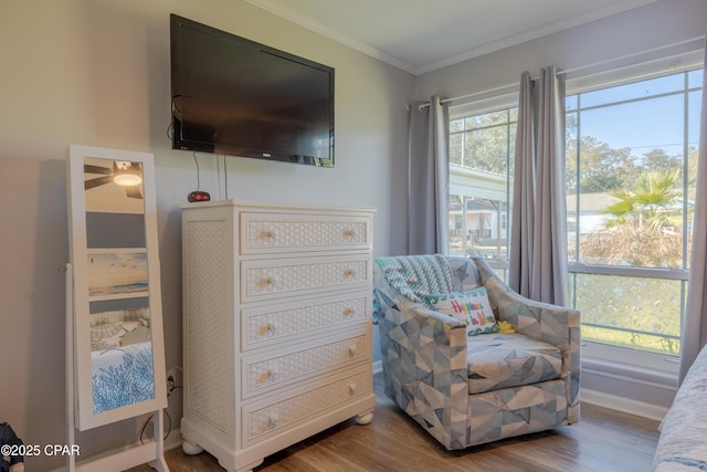 sitting room featuring ornamental molding and wood-type flooring