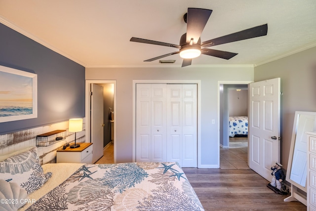 bedroom featuring hardwood / wood-style flooring, ornamental molding, a closet, and ceiling fan