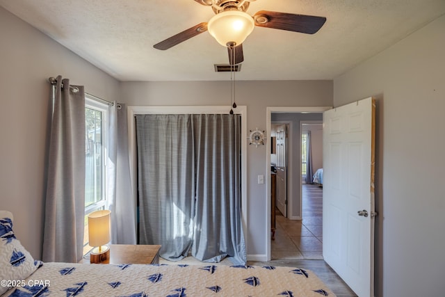 bedroom with ceiling fan and a textured ceiling