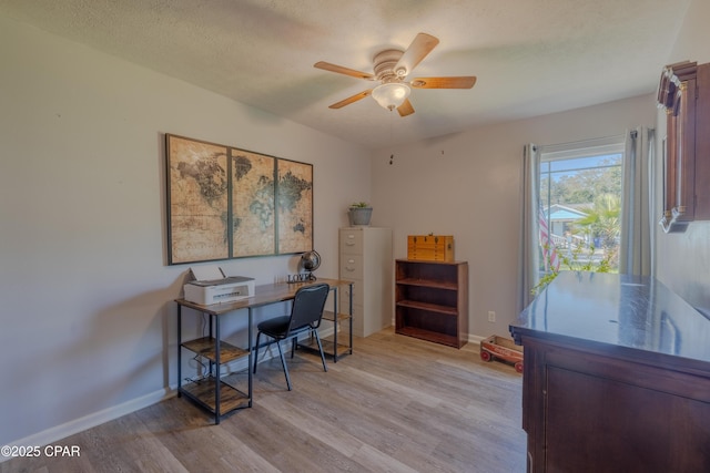 home office with ceiling fan, a textured ceiling, and light hardwood / wood-style flooring