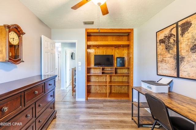 home office with light hardwood / wood-style flooring and ceiling fan