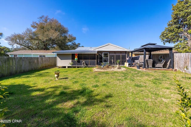 rear view of house with a gazebo, a sunroom, and a yard