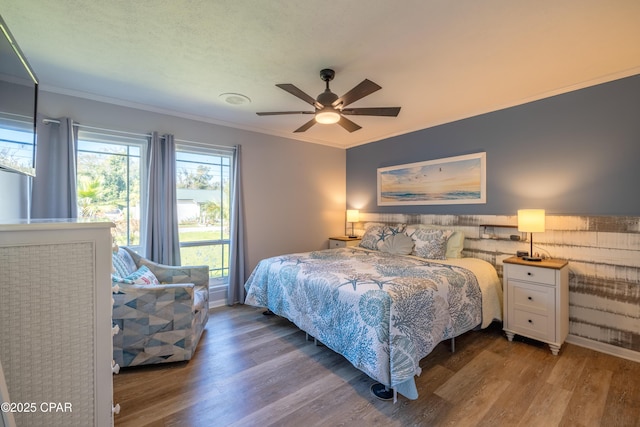 bedroom with hardwood / wood-style floors, a textured ceiling, ornamental molding, and ceiling fan