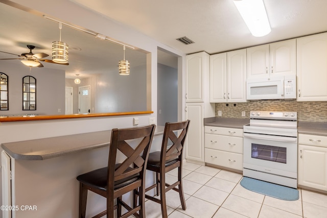 kitchen featuring white appliances, hanging light fixtures, a kitchen breakfast bar, white cabinets, and light tile patterned flooring