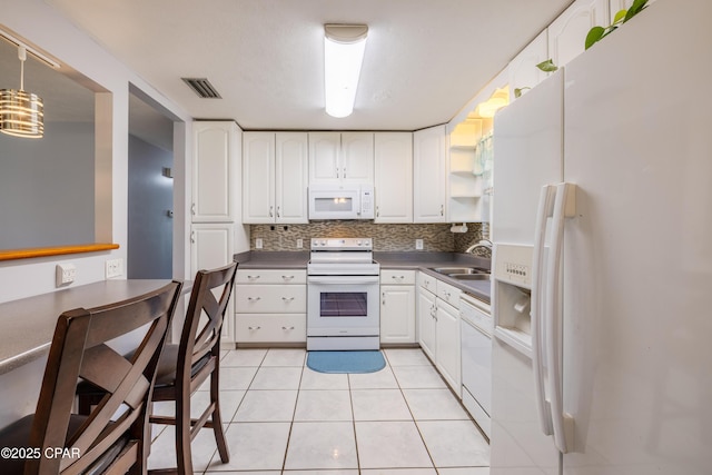 kitchen featuring white appliances, light tile patterned floors, sink, and white cabinets