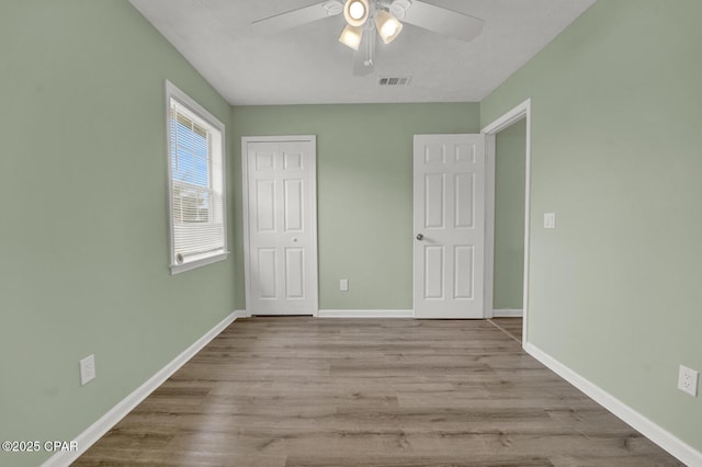 unfurnished bedroom featuring ceiling fan, a closet, and light hardwood / wood-style flooring