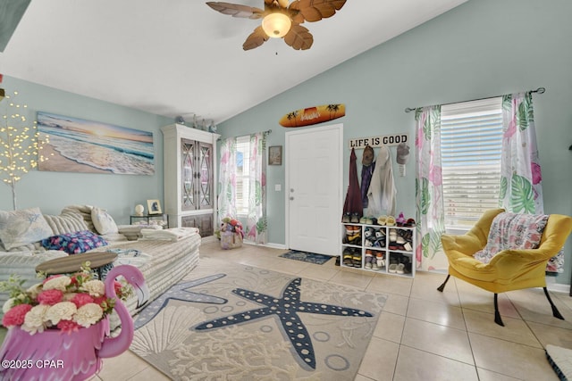 interior space with ceiling fan, lofted ceiling, a wealth of natural light, and light tile patterned floors