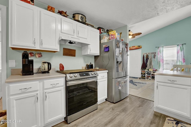 kitchen with white cabinetry, appliances with stainless steel finishes, lofted ceiling, and light wood-type flooring