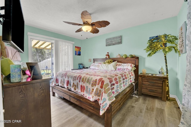 bedroom featuring ceiling fan, access to exterior, a textured ceiling, and light hardwood / wood-style flooring