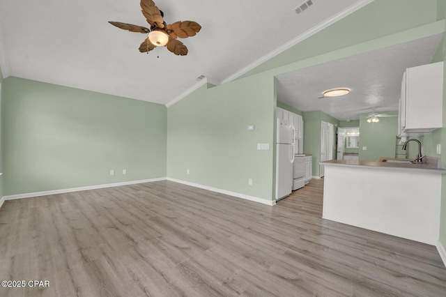 unfurnished living room featuring sink, crown molding, ceiling fan, light hardwood / wood-style floors, and vaulted ceiling