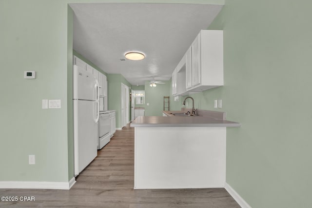 kitchen with white cabinetry, sink, white refrigerator, stove, and light hardwood / wood-style flooring