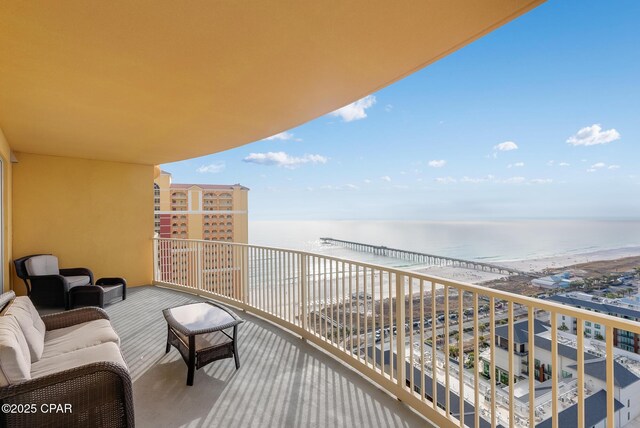 balcony featuring a water view, a view of the beach, and outdoor lounge area