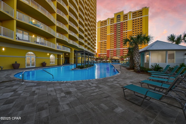 pool at dusk with a patio