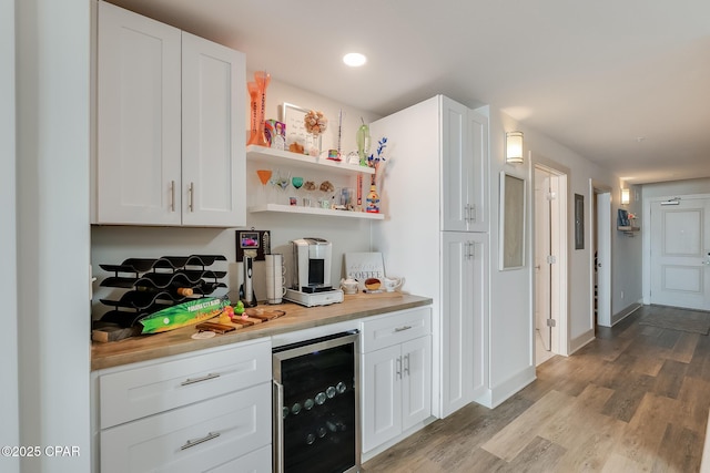 bar featuring butcher block countertops, white cabinetry, beverage cooler, and light hardwood / wood-style floors