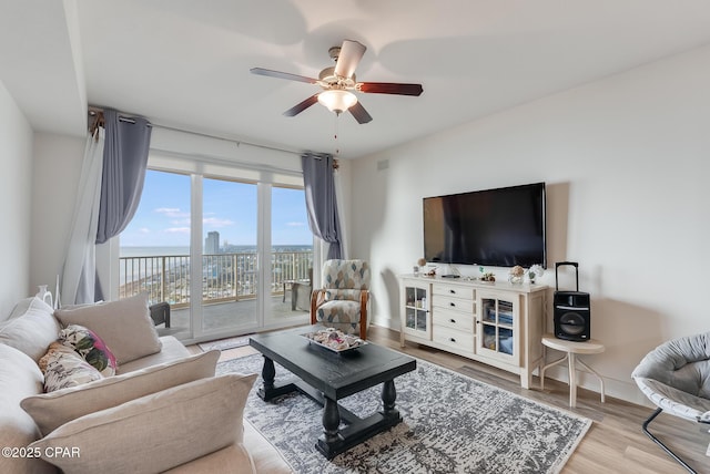 living room featuring ceiling fan and light wood-type flooring