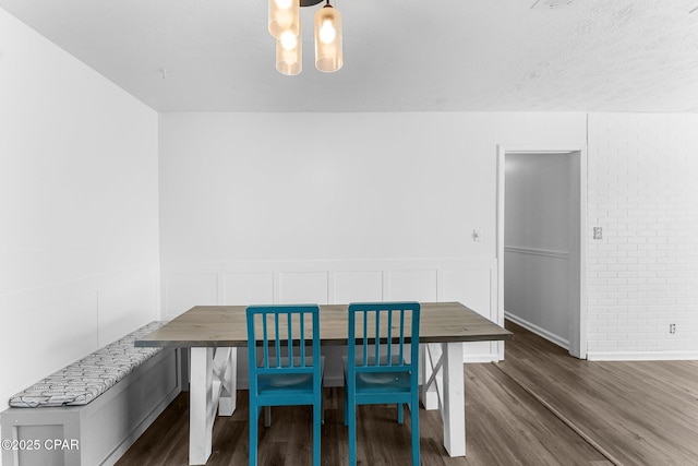 dining area featuring dark wood-type flooring, breakfast area, and a notable chandelier