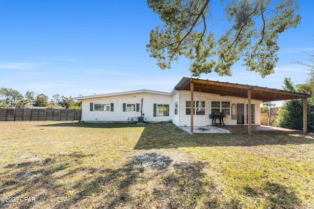 back of property with a patio area and a lawn