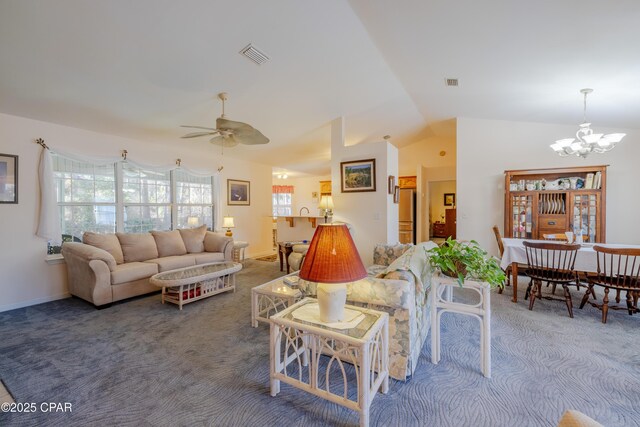 living room featuring ceiling fan with notable chandelier, carpet floors, and vaulted ceiling